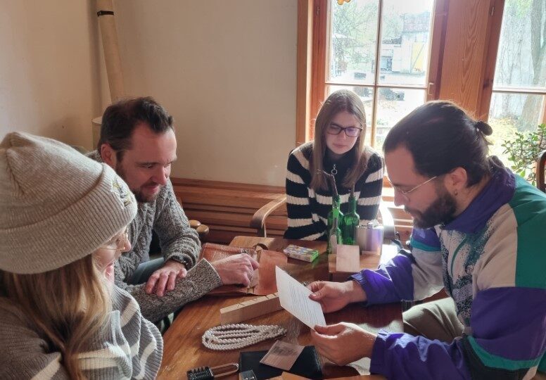 Team 2 sitzt im RätselCafé am Tisch und betrachtet alle gesammelten Hinweise